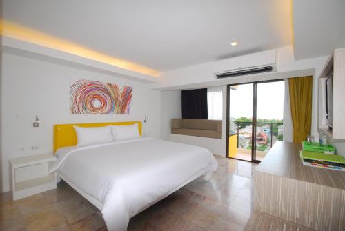 a white bedroom with a large bed and a window at Samui Verticolor in Chaweng