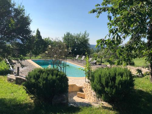 a swimming pool in the middle of a garden at La Colle en Provence Main House in Sigonce