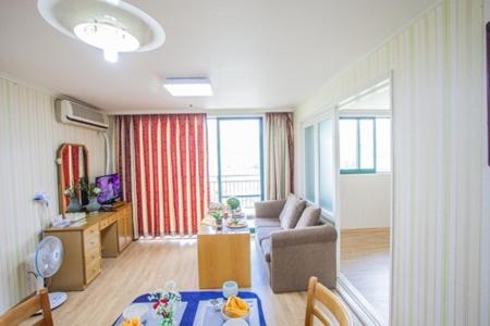 Jiri Mountain Ilsung Condo في Namwon: غرفة معيشة مع أريكة وطاولة