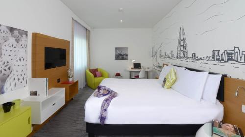 a hotel room with a bed and a tv at ibis Styles Manama Diplomatic Area in Manama