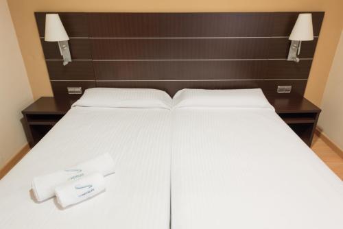 a large white bed with two towels on it at Las Ventas in Utebo
