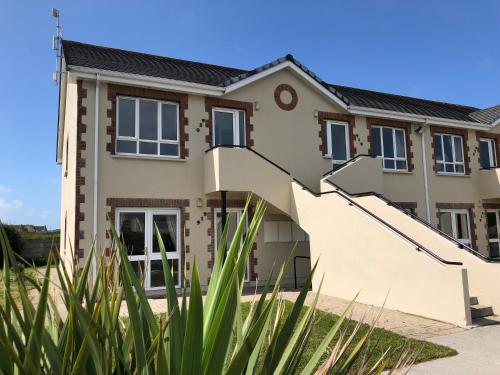a house with stairs in front of it at Kilkee Holiday Homes Type A by Trident Holiday Homes in Kilkee