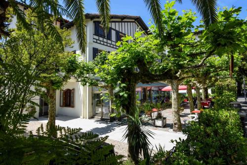 un edificio con alberi di fronte di Logis Hotel & Restaurant Bergeret Sport a Hendaye