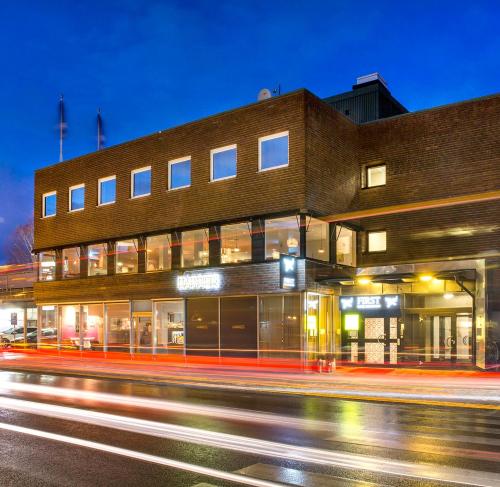 a building on the side of a street at night at First Hotel Dragonen in Umeå