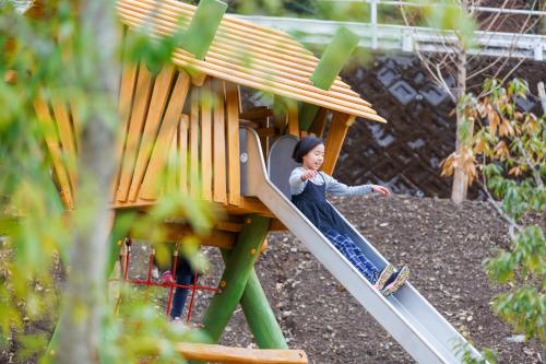 a woman on a slide on a playground at Mt Fuji View Villa Fujino Kirameki Fujigotemba in Gotemba