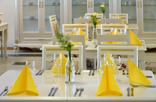 a table with yellow napkins and glasses on it at Hotel Golden Dome Iisalmi in Iisalmi
