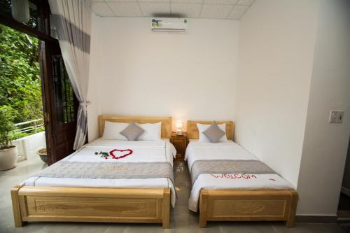 two beds in a room with a window at Shark Homestay in Hue