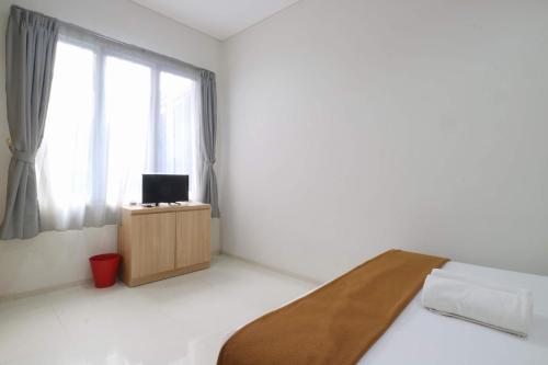 a white room with a bed and a window at Mk House Tendean in Jakarta