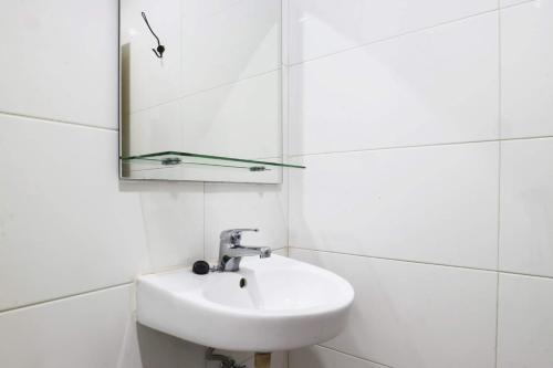a white bathroom with a sink and a mirror at Mk House Tendean in Jakarta