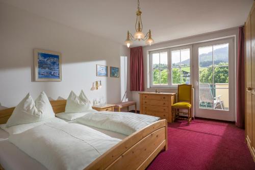 Schlafzimmer mit einem Bett, einem Schreibtisch und einem Fenster in der Unterkunft Apparthotel Tom Sojer in Ellmau