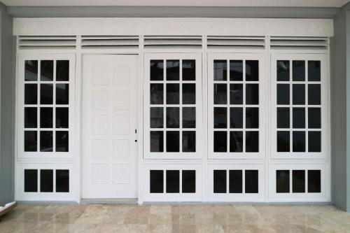 a garage with two white doors with windows at Mk House Tendean in Jakarta