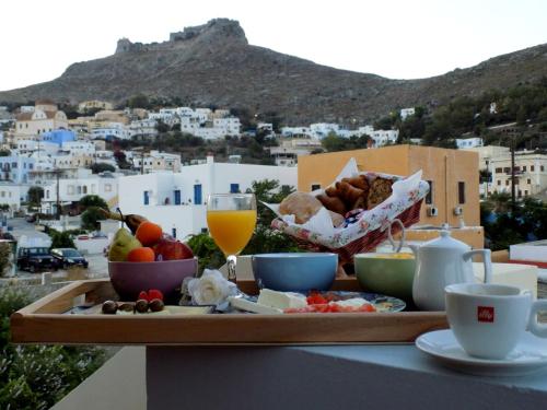 uma bandeja de comida e bebidas numa mesa com vista em Anemi Leros Apartments em Panteli