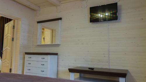 a bedroom with a television on a wall with a table at Family Hotel Kaskad in Bukovel