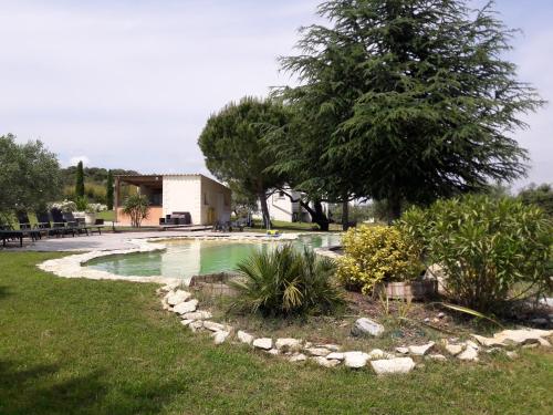 una piscina en un patio con un árbol en La Lune ô Collines - Gîte, en Lédenon
