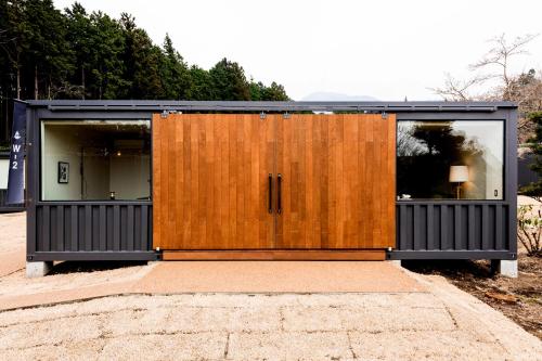 a building with a wooden door on a street at Mt Fuji View Villa Fujino Kirameki Fujigotemba in Gotemba