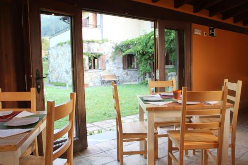 EcoHotel Rural Angiz في Busturia: غرفة طعام مع طاولة وكراسي ونافذة