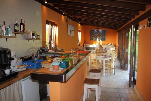 een keuken met een aanrecht en een aantal tafels en stoelen bij EcoHotel Rural Angiz in Busturia