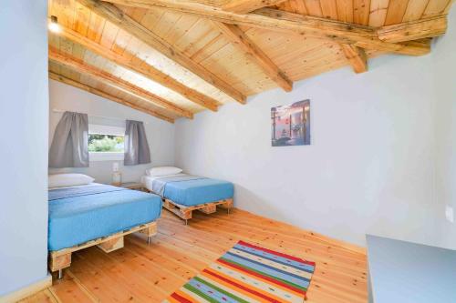 タソスにあるKalliston Beach Apartmentsの木製の天井が特徴のベッドルーム1室(ベッド2台付)