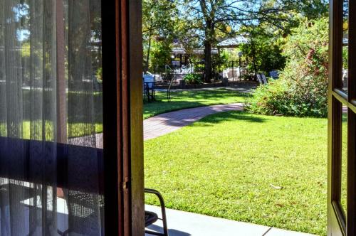 an open glass door with a view of a yard at River Country Inn in Moama
