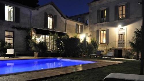a swimming pool in front of a house at night at Chambres d'Hôtes Maison La Porte Rouge in Niort