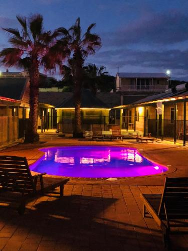 a swimming pool with purple lights in a courtyard at Bay Lodge in Denham