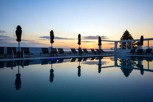 a group of chairs sitting next to a swimming pool at Rochari Hotel in Mýkonos City