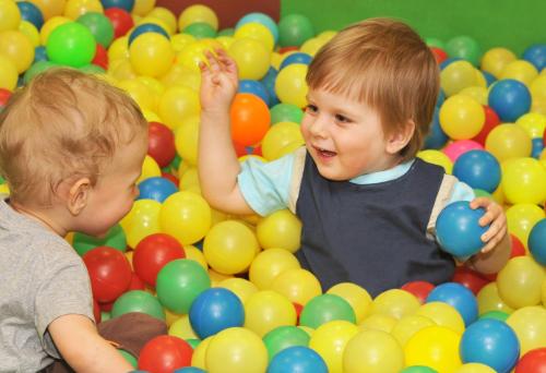 two young children playing in a pile of balls at Club St. George in Paphos City