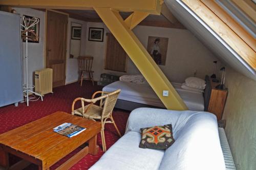 HeythuysenにあるDe Hoge Peelのベッド2台、テーブル、ソファが備わる客室です。