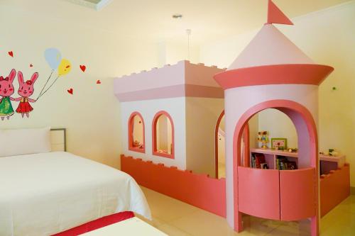 a bedroom with a large play house on the wall at Kid Baby Homestay in Anping