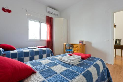 sypialnia z 2 łóżkami, stołem i biurkiem w obiekcie Villa Leomar w Maladze