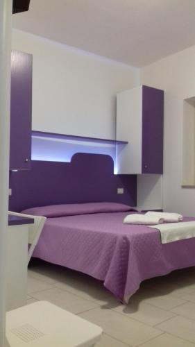 a bedroom with a purple bed and purple cabinets at Il Corvino in Diamante