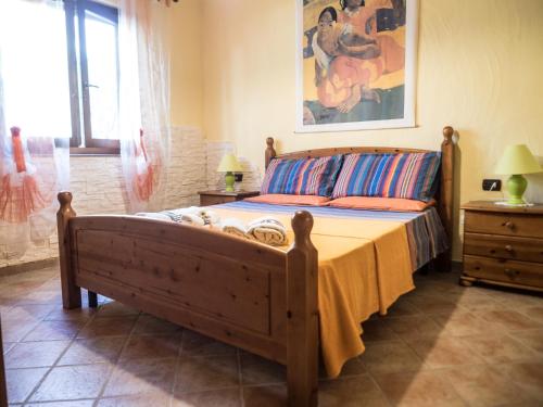 sypialnia z łóżkiem i obrazem na ścianie w obiekcie Villetta Rombi w mieście Calasetta