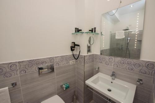 ein Badezimmer mit Waschbecken und Spiegel in der Unterkunft La Suite Tropea in Tropea