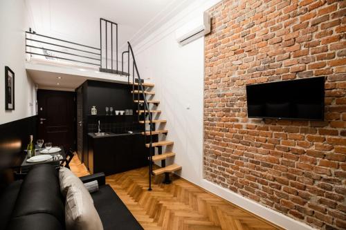 a living room with a brick wall and a couch at DIETLA 99 APARTMENTS - IDEAL LOCATION - in the heart of Krakow in Kraków