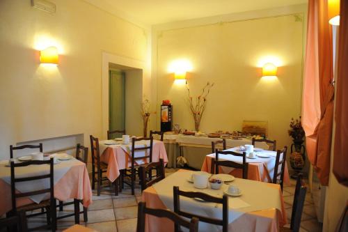 マンチャーノにあるHotel Rossiのテーブルと椅子が備わるレストラン