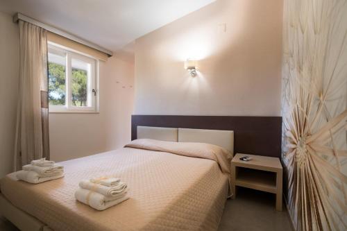 1 dormitorio con 1 cama con toallas en B&B Nacorè, en Massafra