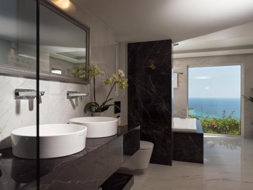 a bathroom with two sinks and a large mirror at Golden July Luxury Villa in Akrotiri