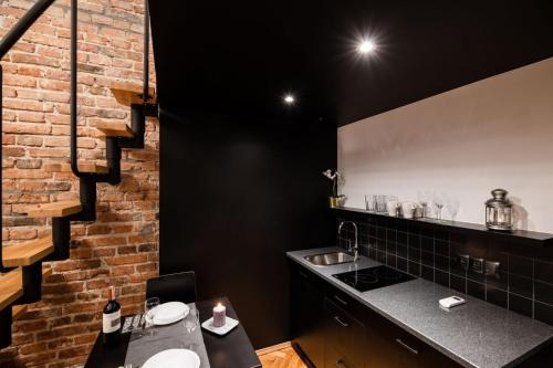 a kitchen with a sink and a brick wall at DIETLA 99 APARTMENTS - IDEAL LOCATION - in the heart of Krakow in Kraków