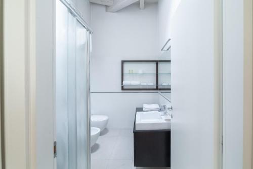 a white bathroom with a toilet and a sink at La Betulla in Mantova