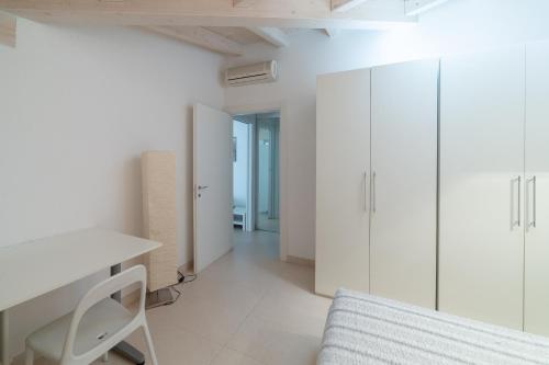 Habitación blanca con escritorio y armarios blancos. en La Betulla, en Mantua