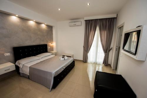 ein Schlafzimmer mit einem großen Bett und einem großen Fenster in der Unterkunft La Suite Tropea in Tropea