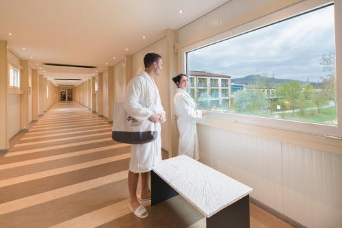 two doctors standing in a hallway looking out a window at Best Western Plus Kurhotel an der Obermaintherme in Bad Staffelstein
