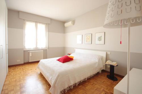 a bedroom with a white bed with a red pillow at Casa Francesca in Salò