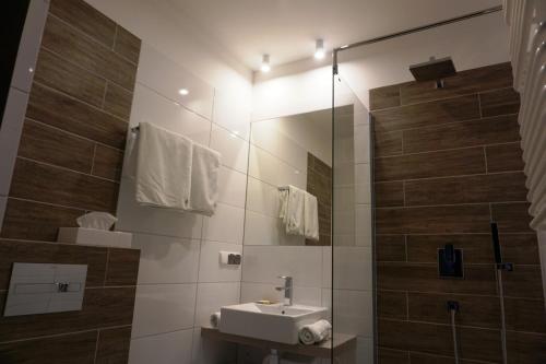 a bathroom with a sink and a shower at Hotel Restauracja Varia in Działdowo