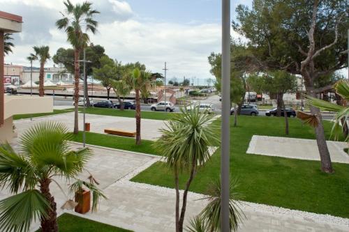 a park with palm trees and a street with cars at Via Stazione 5 in Praia a Mare