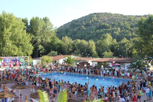 a large crowd of people standing around a swimming pool at Villaggio Marbella Club in Palinuro