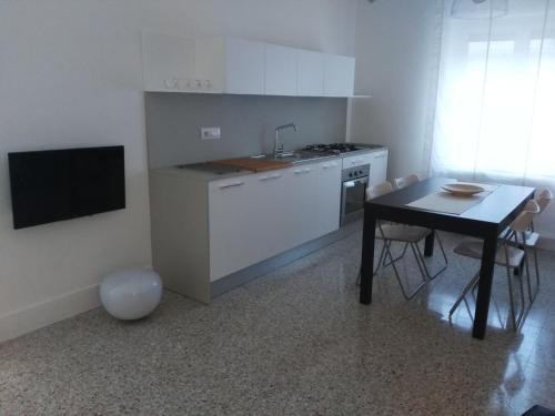 uma cozinha com uma mesa, um fogão e um lavatório em Via Stazione 5 em Praia a Mare