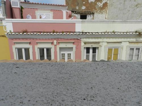 a pink and white building in front of a building at Casa Da Baixa in Faro