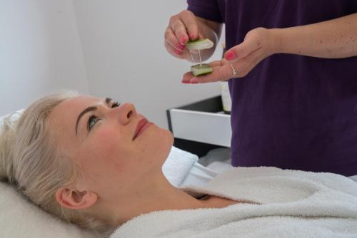 a woman laying in a hospital bed getting her face examined at Best Western Plus Kurhotel an der Obermaintherme in Bad Staffelstein