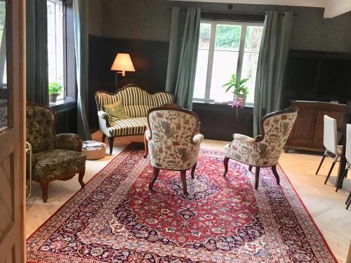 a living room with two chairs and a rug at Björnhofvda Gård in Björnhuvud